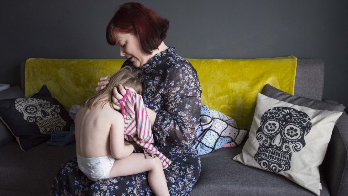 Leatherbarrow dresses her daughter Martha, 3, for school.