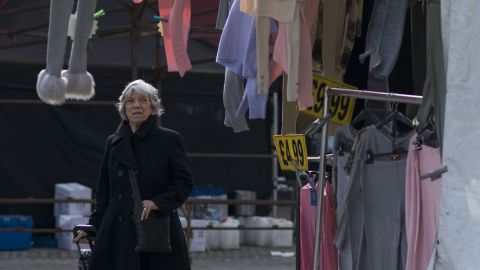A woman browses through clothes at a market stall.