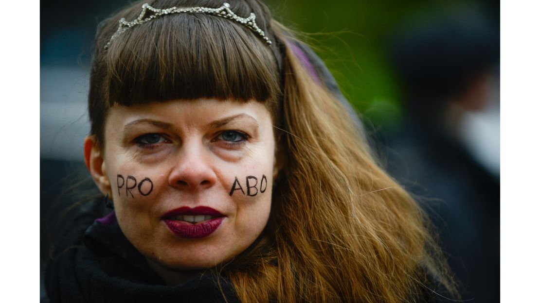 A woman with "Pro Abo" face paint attends a protest against a proposed  law to tighten abortion in Warsaw.