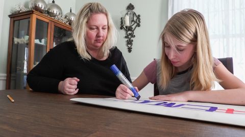 Lauren Milgram makes a sign to take to March for Our Lives with her mother, Erin