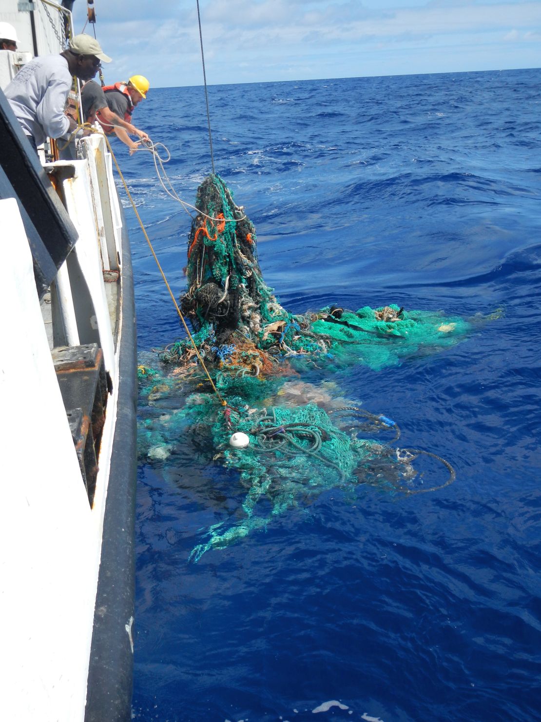 The crew pulling a ghost net from the Pacific Ocean.