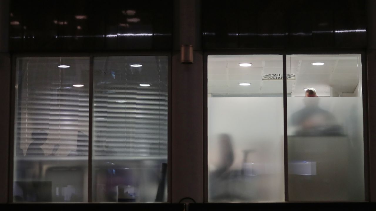People are seen Friday in Cambridge Analytica's London offices after a search warrant's approval.