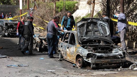 Investigators look over a vehicle destroyed in the Alexandria bombing.