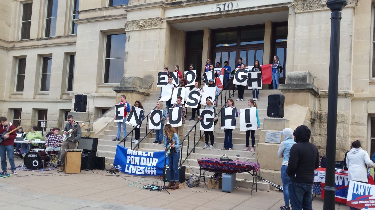 Kansas students holding up Hartman's sign. At the bottom of each letter, she listed the names of a Parkland victim.