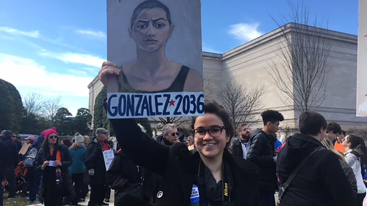 Becky Quiroga in Washington holds the poster she painted.