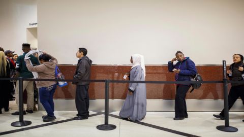 The commotion of the airport frightened Batulo at first. Now she's familiar with the routines of this place, like the security line where she waits with other employees. (Melissa Golden/Redux for CNN)