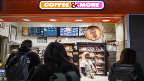 Batulo serves drinks to customers at the airport Dunkin' Donuts. Occasionally, she helps lost passengers find their way. (Melissa Golden/Redux for CNN)