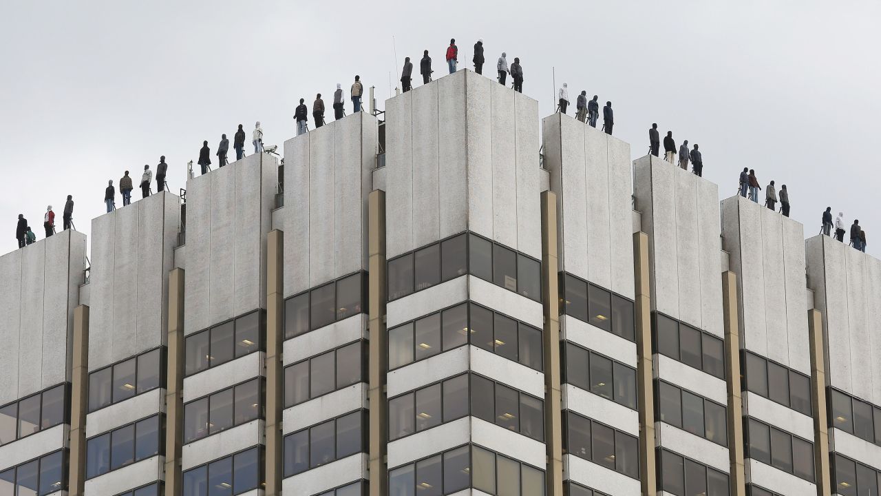 These statues atop a London building represent the 84 men who commit suicide every week in the UK. 