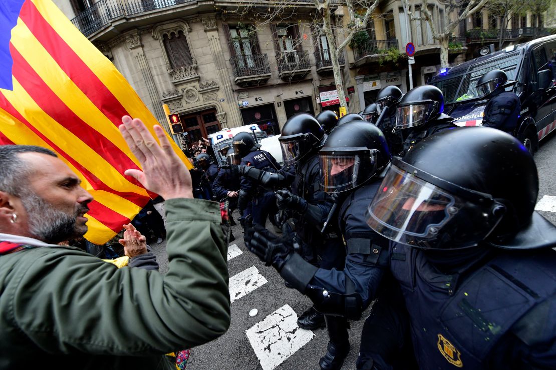 Protesters scuffle with riot police at a demonstration in Barcelona on March 25, 2018.