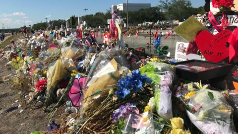 The memorial at Marjory Stone Douglas High School includes piles of flowers and messages.