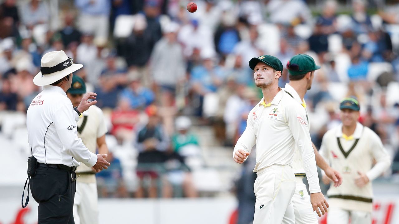 Australian fielder Cameron Bancroft (R) throws the ball to Umpire Richard Illingworth (L) during the third day of the third Test cricket match between South Africa and Australia at Newlands cricket ground on March 24, 2018 in Cape Town. / AFP PHOTO / GIANLUIGI GUERCIA        (Photo credit should read GIANLUIGI GUERCIA/AFP/Getty Images)