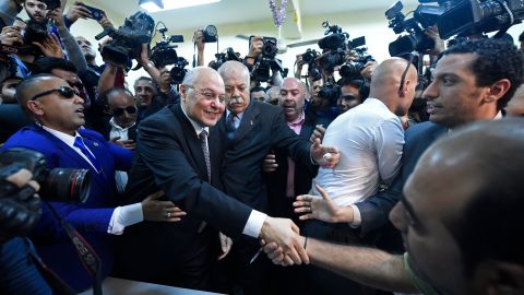 Egyptian presidential candidate Mousa Mostafa Mousa shakes hands with supporters ahead of casting his vote Monday.