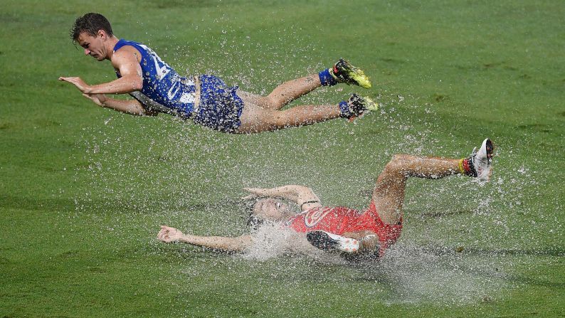 Gold Coast's Lachie Weller, bottom, is tackled by North Melbourne's Kayne Turner during an Australian Football League match on Saturday, March 24.