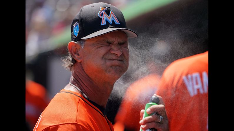 Miami manager Don Mattingly sprays sunscreen on his face before a spring-training game in Jupiter, Florida, on Wednesday, March 21.