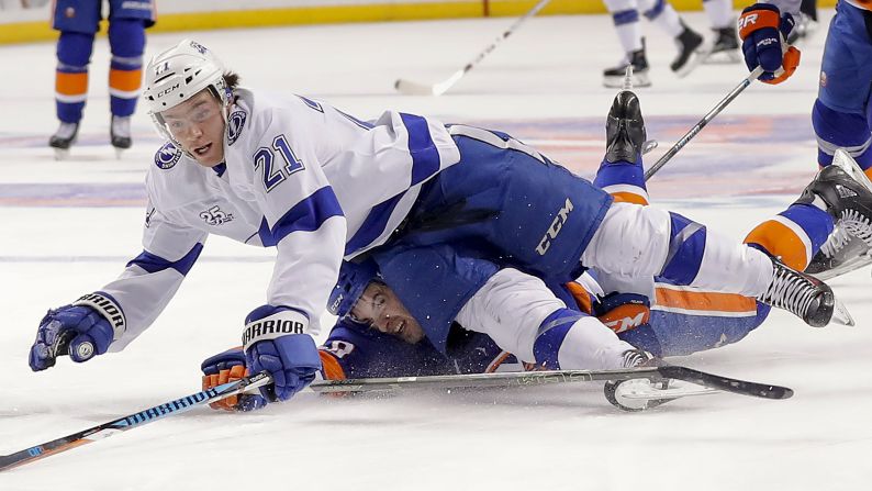 Tampa Bay's Brayden Point, top, is tripped by New York Islanders defenseman Adam Pelech during an NHL game in New York on Thursday, March 22.