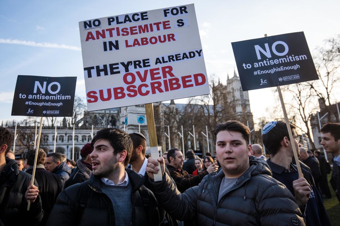 Protesters hold placards as they demonstrate in Parliament Square.