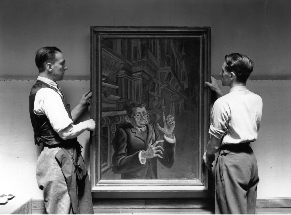 Two men hang a portrait by Otto Dix at an exhibition of "degenerate" German art at the New Burlington Galleries, London in 1938. The exhibition featured work by artists who had been pilloried by Adolf Hitler.