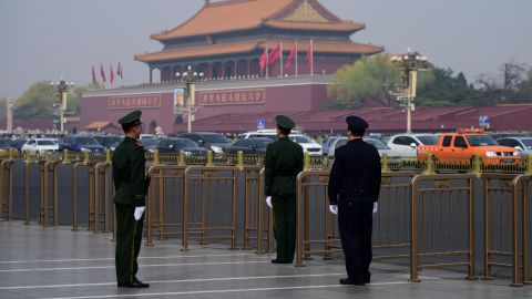 A police and two paramilitary police officers take position near Tiananmen Square on Tuesday.