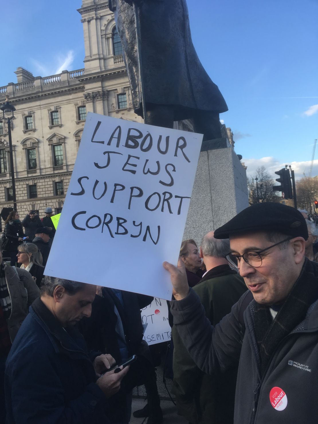Brian Chinnery holds a poster while protesting with the Jewish Voice for Labour group.