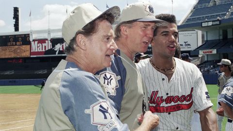 Television talk show host Regis Philbin, left, Donald Trump, center, and daytime television actor Kristoff St. John, pose for photographers before the third annual celebrity softball game at Yankee Stadium in New York on July 31, 1993. 