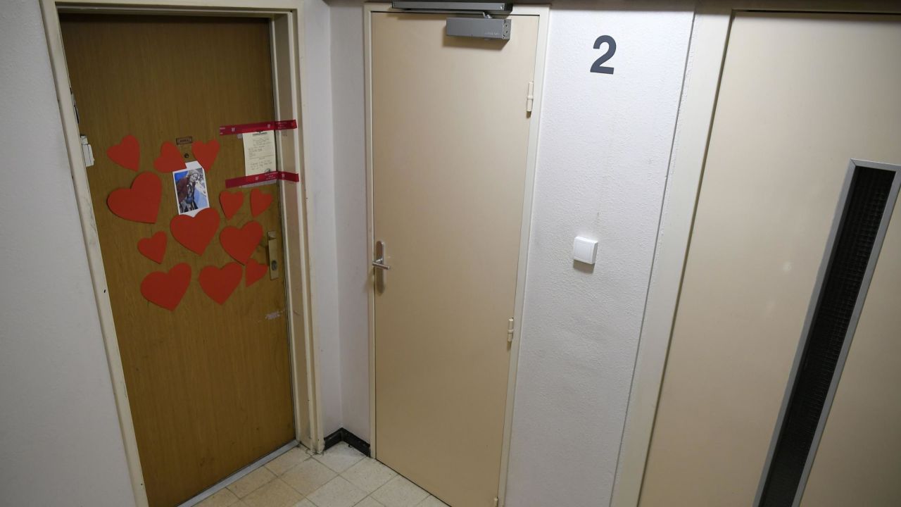A photo taken on Tuesday shows an image of Mireille Knoll, heart-shaped cutouts, and police seals on the door of Knoll's apartment. 