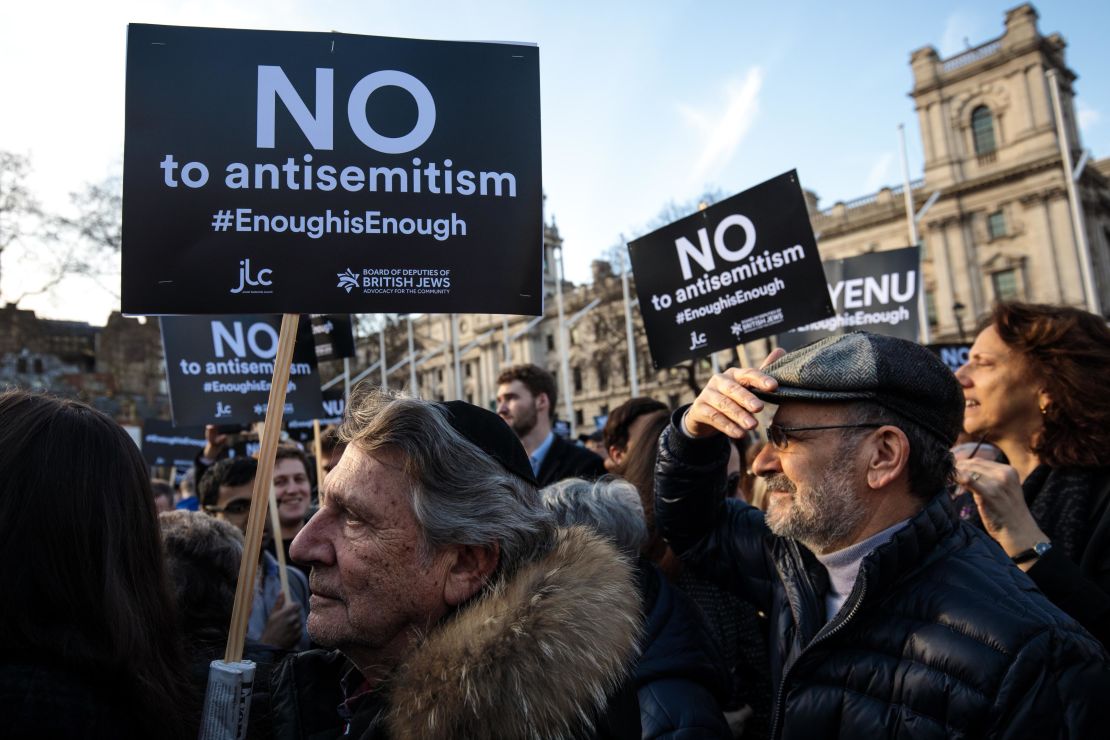 Protesters hold placards as they demonstrate in Parliament Square against anti-Semitism on March 26, 2018 in London.