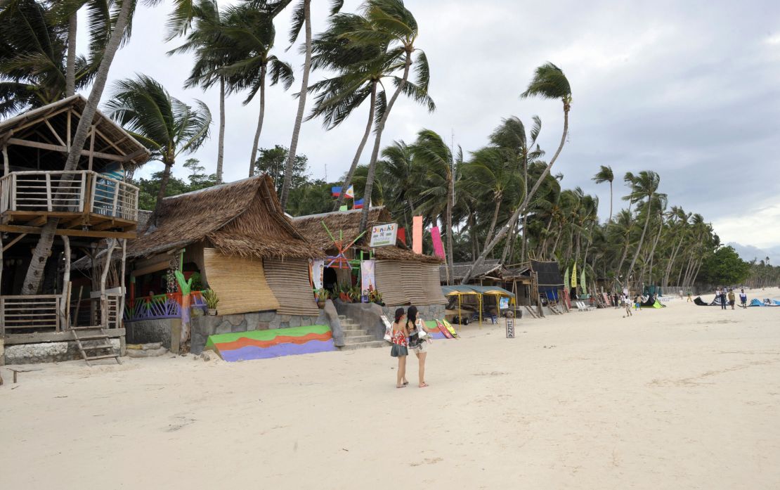 Tourists walk along Boracay's beach in 2008.