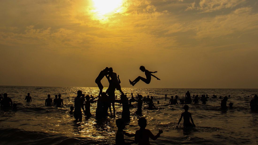<strong>Mumbai, India: </strong>A group of tourists forms a human pyramid at sunset on Mumbai's Juhu Beach on March 25, as the city recorded one of its hottest March days ever, with temperatures rising to 41 C (106 F). 