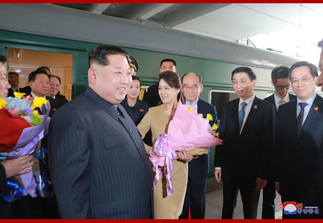 Kim Jong Un and his wife Ri Sol Ju are seen outside what appears to be the Kim's family train car in Beijing in a photograph released by North Korean state media.