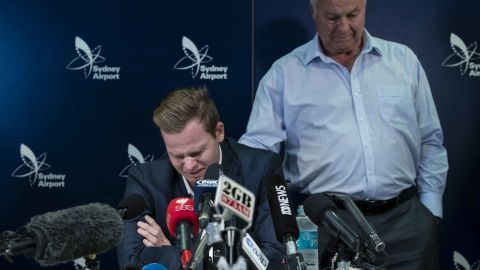 An emotional Steve Smith is comforted by his father Peter as he fronts the media at  Sydney International Airport.