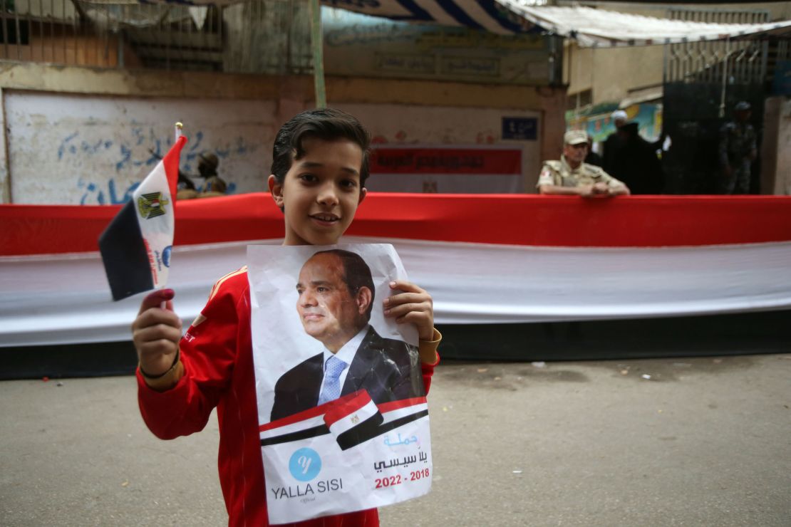 A boy holds a poster of Egyptian President Sisi on the last day of voting.