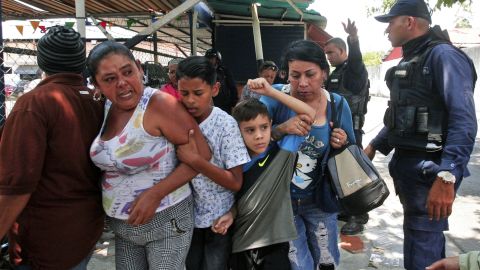 Police officers disperse the relatives of prisoners who were waiting to hear news about family members imprisoned at the police station.