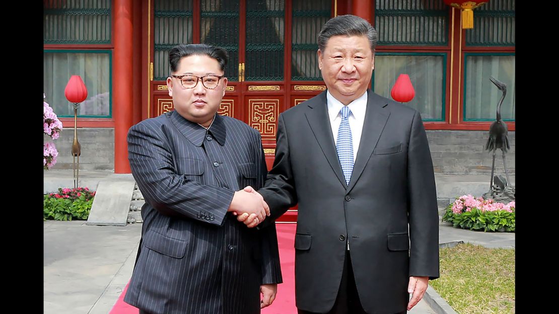 A photograph from North Korea's official Korean Central News Agency (KCNA) released on March 28, 2018 shows China's President Xi Jinping (right) shaking hands with North Korean leader Kim Jong Un in Beijing.