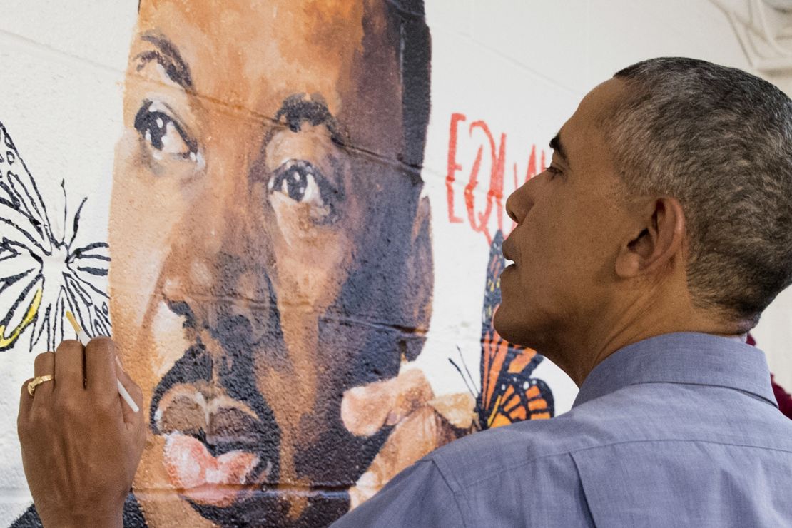 U.S. President Barack Obama helps paint a mural depicting Martin Luther King Jr.