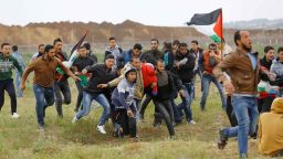EDITORS NOTE: Graphic content / A picture taken on March 30, 2018 shows a Palestinian youth being carried by other protesters during clashes after a demonstration near the border with Israel east of Jabalia in the Gaza strip commemorating Land Day.
Land Day marks the killing of six Arab Israelis during 1976 demonstrations against Israeli confiscations of Arab land. / AFP PHOTO / Mohammed ABED        (Photo credit should read MOHAMMED ABED/AFP/Getty Images)