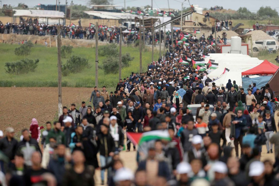 Palestinians march past a tent city erected along the border with Israel east of Gaza City on Friday. 