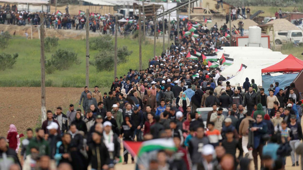 Palestinians march past a tent city erected along the border with Israel east of Gaza City on Friday. 