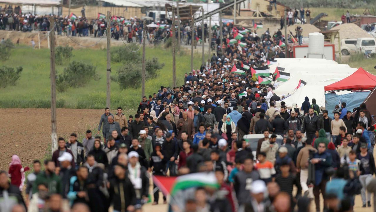 Palestinians march past a tent city erected along the border with Israel east of Gaza City on Friday.