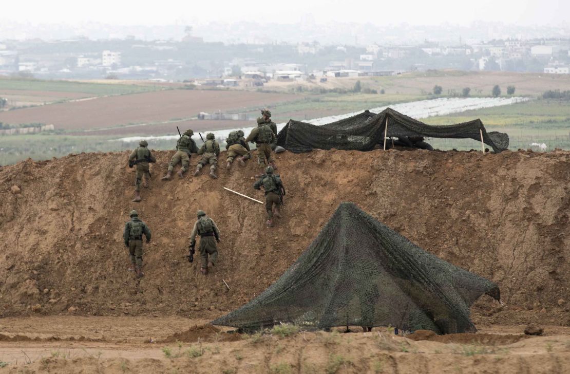Israeli soldiers take up positions at the border.