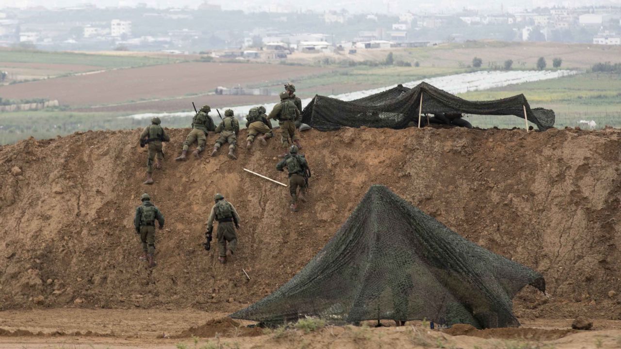 Israeli soldiers take up positions at the border.