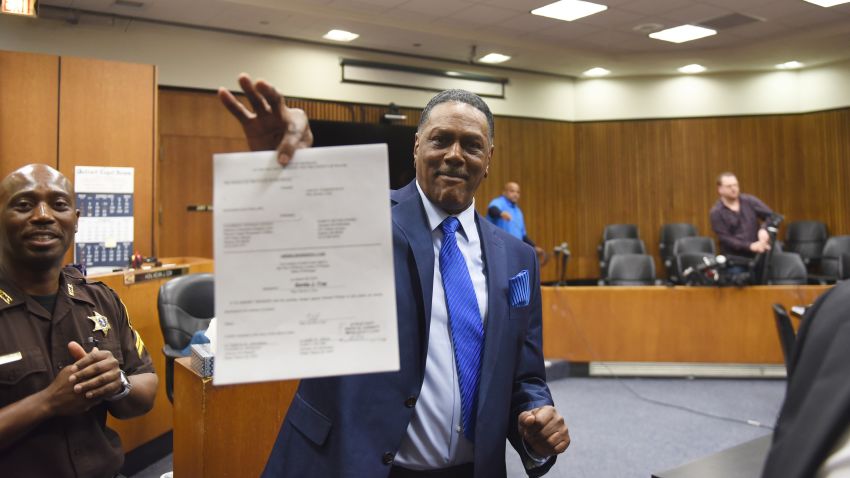 Richard Phillips shows his order of dismissal of homicide charges against him in Judge kevin Cox's courtroom at the Frank Murphy Hall of Justice in Detroit on Wednesday, March 28, 2018. Phillips, whose murder conviction was thrown out after he spent 45 years in prison, was exonerated Wednesday and won't face a second trial. (Max Ortiz/Detroit News via AP)