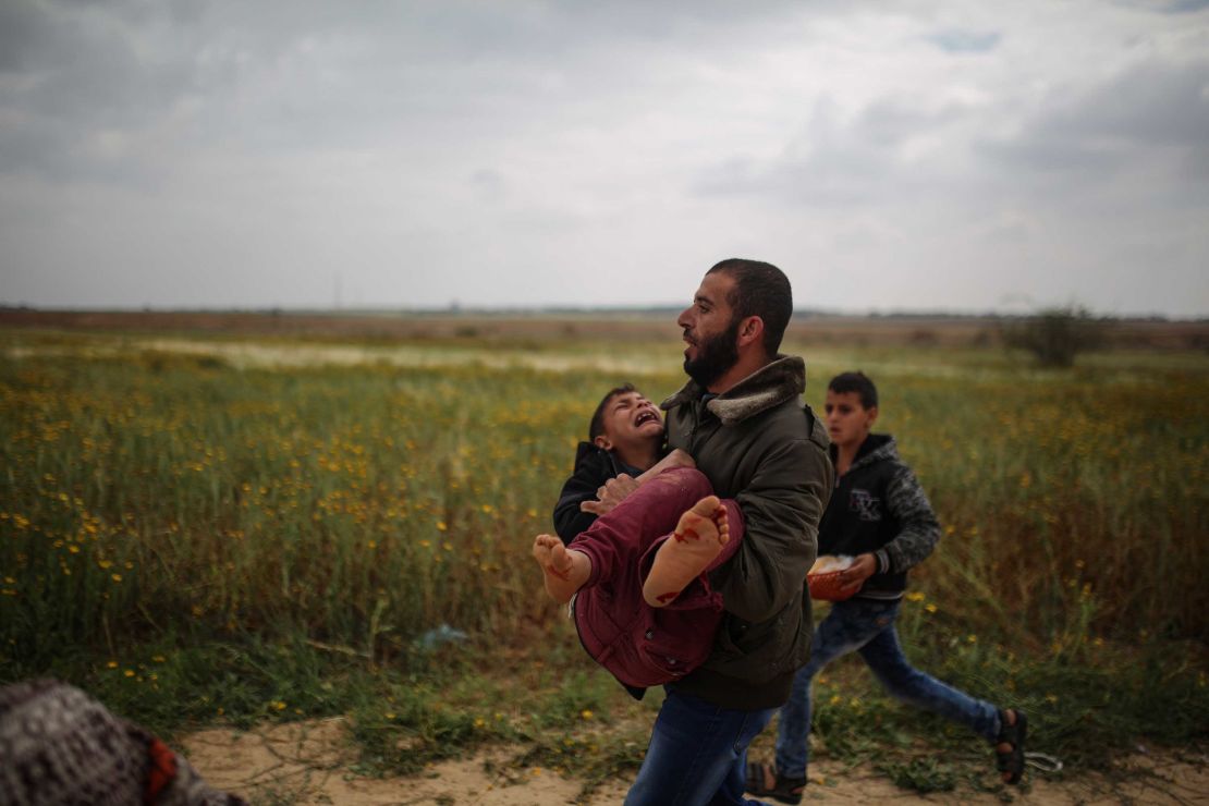 A Palestinian man carries a wounded boy away from protests in Gaza on Friday. 