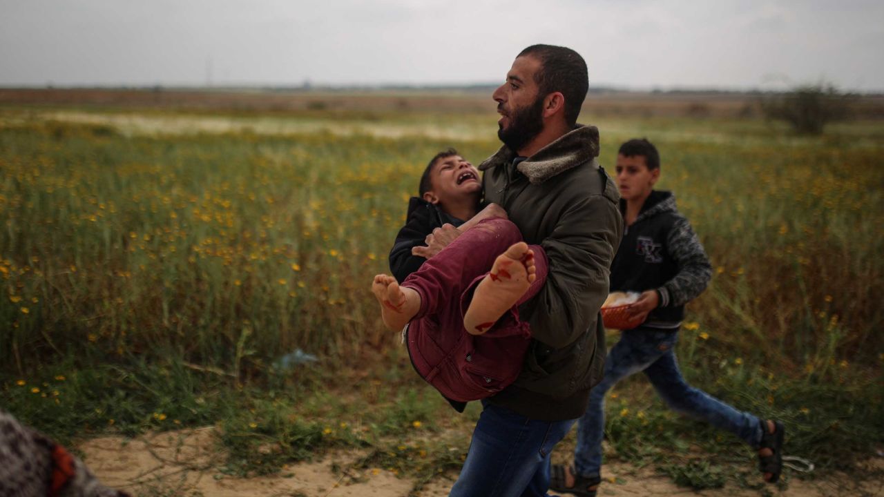 A Palestinian man carries a wounded boy away from protests in Gaza on Friday.