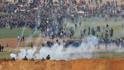TOPSHOT - A picture taken on March 30, 2018 from the southern Israeli kibbutz of Nahal Oz across the border from the Gaza strip shows tear gas grenades falling during a Palestinian tent city protest commemorating Land Day, with Israeli soldiers seen below in the foreground.Land Day marks the killing of six Arab Israelis during 1976 demonstrations against Israeli confiscations of Arab land. / AFP PHOTO / Jack GUEZ        (Photo credit should read JACK GUEZ/AFP/Getty Images)