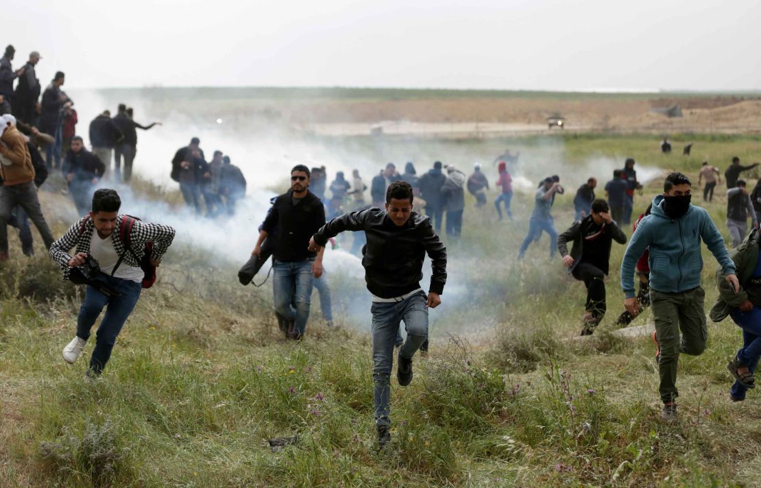 Palestinian protesters flee tear gas during clashes with Israeli forces at the Gaza border on Friday. 
