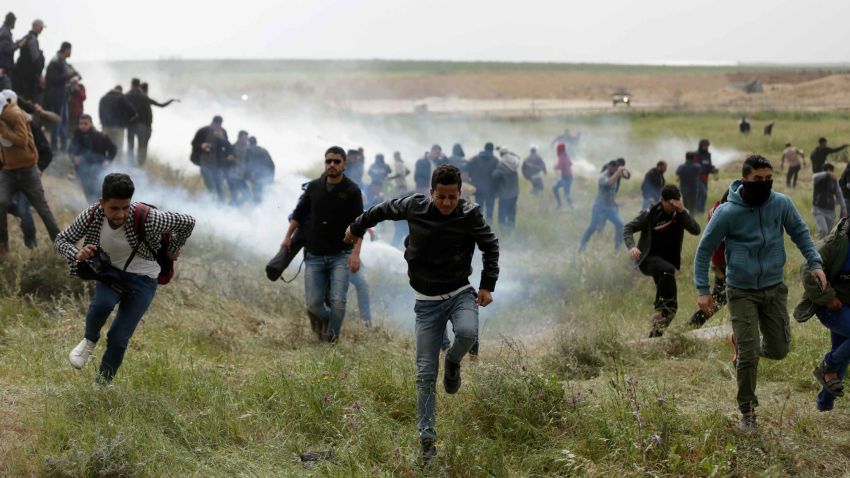 Palestinian protesters flee from tear gas during clashes near the border with Israel east of Gaza City during a demonstration commemorating commemorate Land Day on March 30, 2018.Land Day marks the killing of six Arab Israelis during 1976 demonstrations against Israeli confiscations of Arab land. / AFP PHOTO / MAHMUD HAMS        (Photo credit should read MAHMUD HAMS/AFP/Getty Images)