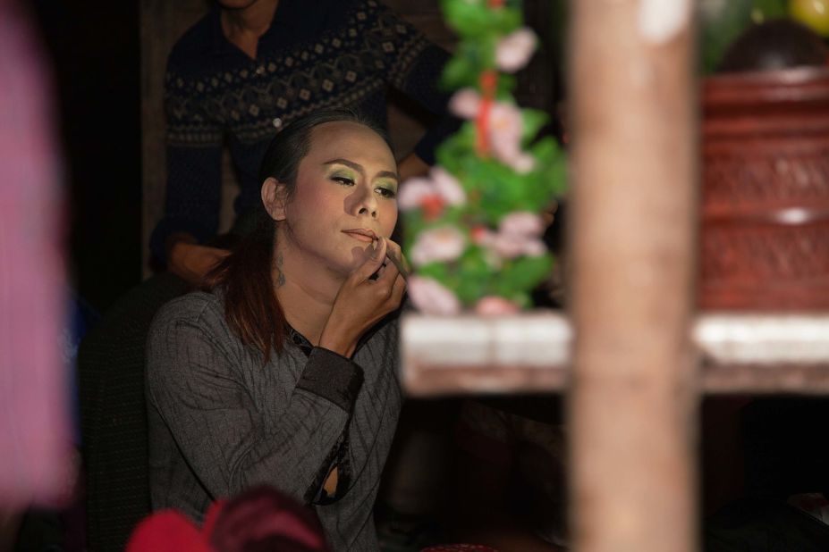 Spirit medium Tinko applies makeup before a religious ceremony.