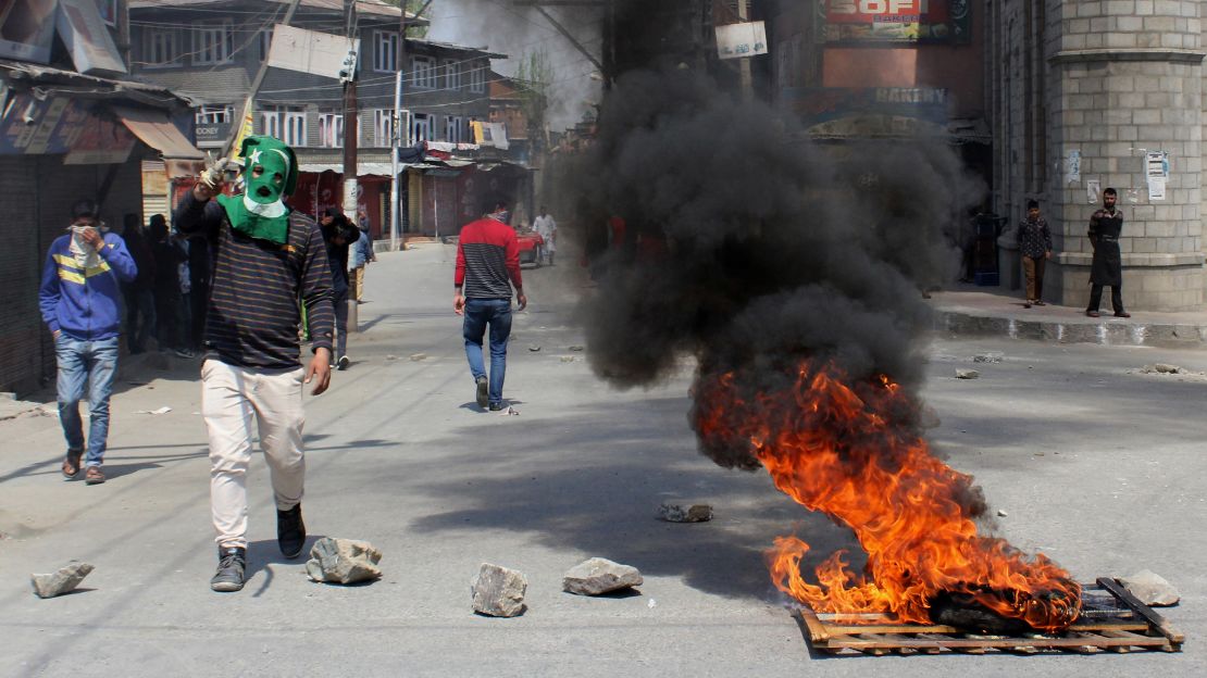 Indian Kashmiris stand along a barricaded street during unrest following gun fights between suspected militants and Indian forces in South Kashmir, in Srinagar on April 1, 2018.
