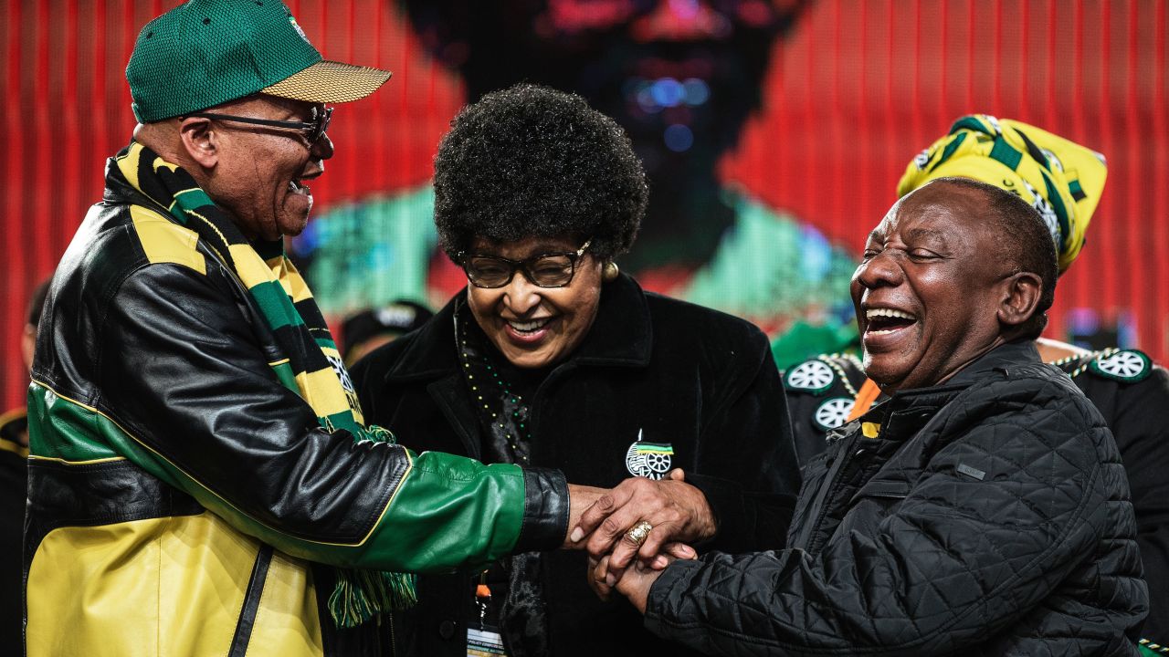 Winnie Mandela (C) holds the hands of then-President Jacob Zuma (L) and future President Cyril Ramaphosa at the ANC conference in June 2017. 