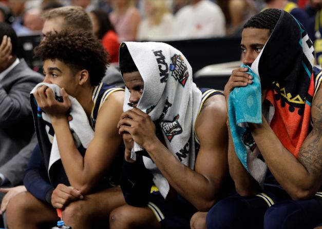 Dejected Michigan players watch from the bench late in the second half.